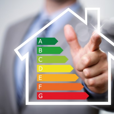 Businessman pointing to energy efficiency rating chart and house icon concept for performance, efficiency and environmental conservation